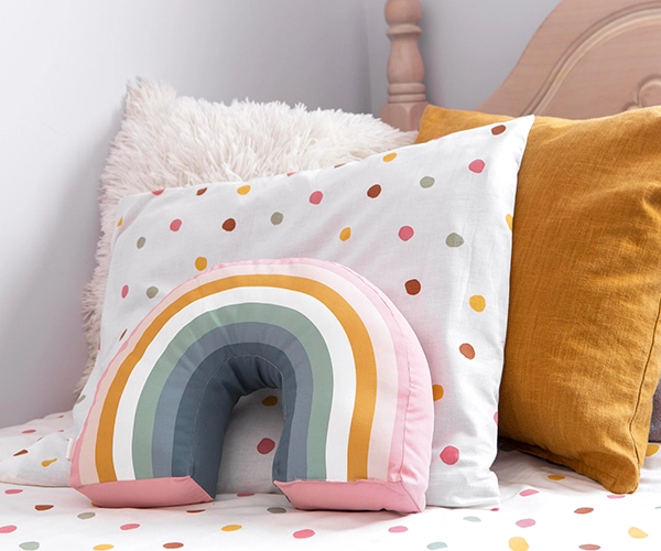 Cojines infantiles con diseño arcoíris en dormitorio juvenil